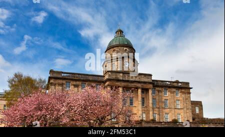 DR GRAUT KRANKENHAUS ELGIN MORAY SCHOTTLAND MIT ROSA KIRSCHBLÜTE PRUNUS DIE VORDERSEITE DES HAUPTGEBÄUDES UND KIRSCHBÄUME Stockfoto