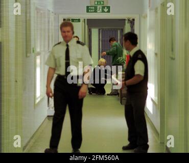 FELTHAM: JUNGE STRAFTÄTERIN, JUGENDEINHEIT. EIN GEFÄNGNISBEAMTER FRICKELTE EINEN STRAFTÄTER IM ERZIEHUNGSFLÜGEL. Stockfoto