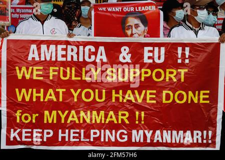 Lashio, North Shan State, Myanmar. Februar 2021. Anti-Militär-Putsch-Demonstranten halten ein Transparent mit der Aufschrift: „Amerika & EU, Wir unterstützen voll und ganz, was Sie für Myanmar getan haben! Helfen Sie Myanmar weiterhin bei einer friedlichen Demonstration gegen den Militärputsch.EINE riesige Menschenmenge ging auf die Straßen von Lashio, um gegen den Militärputsch zu protestieren und forderte die Freilassung von Aung San Suu Kyi. Das Militär in Myanmar nahm am 01. Februar 2021 die staatliche Counselor von Myanmar, Aung San Suu Kyi, fest und erklärte den Ausnahmezustand, während sie die Macht im Land für ein Jahr nach dem Verlust der Wahl gegen die Na ergattete Stockfoto