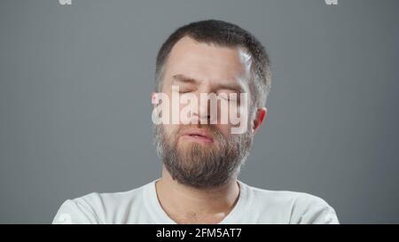 Foto eines bärtigen müden Mannes mit geschlossenen Augen Stockfoto