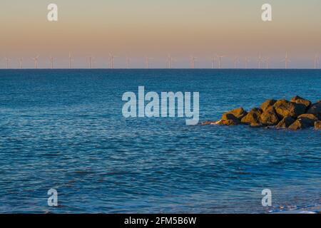 Morgensonne über dem Windpark Gunfleet Sands, von Clacton am Meeresstrand Essex UK aus gesehen. April 2021, Stockfoto