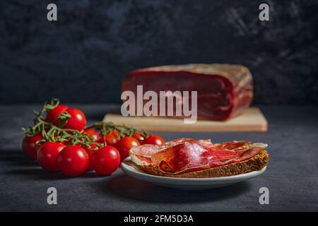 Zubereitetes und leckeres Essen. Serrano-Schinken auf Roggen-Toast, mit Olivenöl und Tomaten. Stockfoto