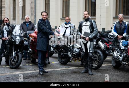 Berlin, 06. Mai 2021, Berlin: Andreas Scheuer (l, CSU), Bundesminister für Verkehr und digitale Infrastruktur, erhält nach einem Treffen im Bundesministerium für Verkehr mit Vertretern von Motorradfahrerverbänden und der Motorradindustrie ein Strategiepapier von Matthias Haasper, Forschungsleiter am Institut für Zweirad-Sicherheit. Minister Scheuer lud im Juli 2020 erstmals Vertreter der Motorradwelt zu einem Runden Tisch ein. Auf der heutigen Sitzung hat die Bundesarbeitsgruppe Motorräder (BAGMO) ein Strategiepapier zur Zukunft des Motorradfahrens in Ge übergeben Stockfoto