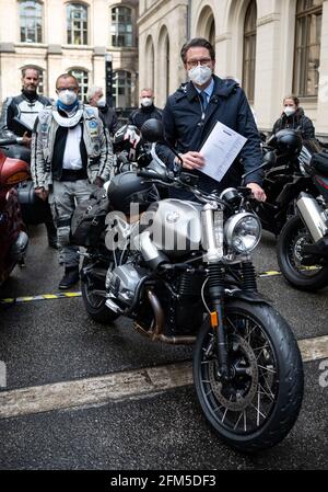 Berlin, 06. Mai 2021, Berlin: Andreas Scheuer (CSU, M), Bundesminister für Verkehr und digitale Infrastruktur, steht nach einem Treffen im Bundesministerium für Verkehr mit Vertretern von Motorradverbänden und der Motorradindustrie an einem BMW-Motorrad. Im Juli 2020 hatte Minister Scheuer erstmals die Vertreter der Motorrad-Community zu einem Runden Tisch eingeladen. Die Bundesarbeitsgruppe Motorräder (BAGMO) hat dem Minister auf der heutigen Sitzung ein Strategiepapier zur Zukunft des Motorradfahrens in Deutschland übergeben, wie vereinbart. Foto: Bernd von Jutrcze Stockfoto