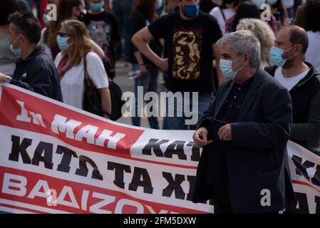 Athen, Griechenland. Mai 2021. Mitglieder der PAME, der mit der Kommunistischen Partei Griechenlands verbundenen Gewerkschaft KKE, halten Nelken fest und winken Fahnen vor dem parlament. Tausende gingen auf die Straße, um den 1. Mai zu feiern und gegen die Deregulierung des Arbeitsmarktes und die Abschaffung des 8-Stunden-Arbeitstages zu protestieren. Quelle: Nikolas Georgiou/ZUMA Wire/Alamy Live News Stockfoto