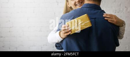 Glücklich lächelnde Frau umarmt Mann nach dem Empfang Geschenk. Geburtstag oder Jahrestag Überraschung. Copy space Stockfoto