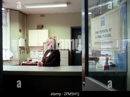 LOKALE FREIWILLIGE HALTEN DIE POLIZEI STATON IN EAST MOLESEY VON MANNING AM SCHREIBTISCH OFFEN. DAS BILD ZEIGT DIE ORTSANSÄSSIGE HASEL BANTING HINTER DEM SCHREIBTISCH DER POLIZEISTATION. Stockfoto