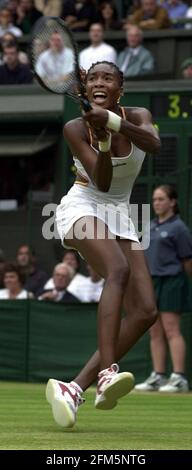 Venus Williams im Einsatz gegen Martina Hingis am 2000. Juli in ihrem Viertelfinalspiel in Wimbledon . Williams gewann in drei Sätzen Stockfoto