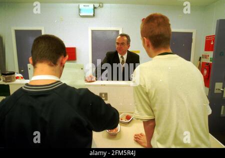 FELTHAM: JUNGE STRAFTÄTERIN, JUGENDEINHEIT. MARTIN NAREY, GENERALDIREKTOR DES GEFÄNGNISDIENSTES, SPRACH MIT ZWEI TÄTERN IN DER KÜCHE DER BILDUNGSEINHEIT. Stockfoto