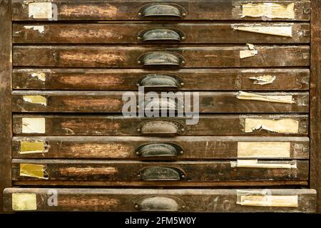 Vertikale Vintage-Holzschubladen mit leeren verwitterten Etiketten Stockfoto