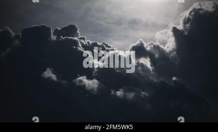 Dunkler stürmischer Himmel mit der Sonne über donnernden Wolken Stockfoto