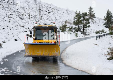 Aviemore, Schottland, Großbritannien. 6 Mai 2021. Heftige nächtliche Schneefälle im Cairngorms National Park gaben der Landschaft einen unsaisonalen winterlichen Blick. Begeisterte Bergsportler machten das Beste aus den Bedingungen, obwohl die Sessellifte geschlossen waren. Das bedeutete lange Spaziergänge die Pisten hinauf, bevor man abseits der Piste abfahren konnte. Bild; Schneepflug, der die Zufahrtsstraße zum Cairgorm Ski Center freilegt. Iain Masterton/Alamy Live News Stockfoto