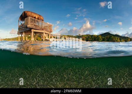 Dock mit Palapas bei Sonnenuntergang Stockfoto