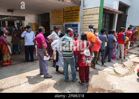 Menschen stehen in einer langen Schlange ohne soziale Distanz, bevor sie einen Covid19-Test in einem Testkioské im ländlichen Madhyamgram-Krankenhaus erhalten. Covid19-Tests werden überall in Indien durchgeführt, um die COVID19-infizierten Patienten aufzuspüren, um die steigende Anzahl von COVID19-Infektionen zu begrenzen. Stockfoto