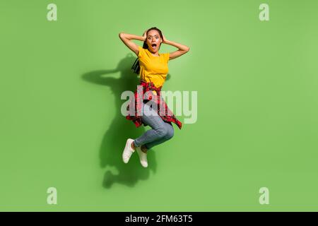 In voller Länge Foto von süß beeindruckt dunkle Haut Dame gekleidet Gelbes T-Shirt Humping Arme Kopf isoliert grüne Farbe Hintergrund Stockfoto