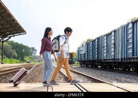 Ein paar stilvolle Touristen mit Rucksäcken und in den Zug an der Außenbahn-Station gehen, asiatische paar Reisen Bahnhof Vintage-Stil Konzept, ich Stockfoto