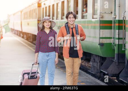 Ein paar stilvolle Touristen mit Rucksäcken und in den Zug an der Außenbahn-Station gehen, asiatische paar Reisen Bahnhof Vintage-Stil Konzept, ich Stockfoto