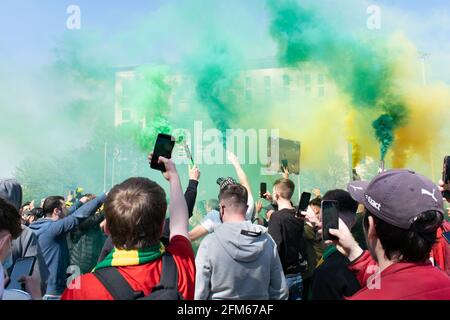 Protest gegen Glazer auf dem Old Trafford Fußballplatz. Unterstützer halten Handy grün und Gold Rauch Flare. Manchester United Stadium, Großbritannien. Stockfoto