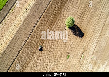 Traktor bei der Arbeit im gepflügten Feld, Luftaufnahme Stockfoto