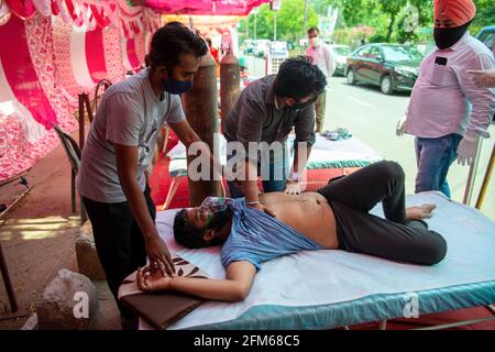 Ghaziabad, Indien. Mai 2021. Ein relativer beschmierender vicks auf der Brust des Covid-19-Patienten während des Oxygen Langar in Gurudwara Sri Guru Singh Sabha Indirapuram, Ghaziabad, Sauerstoff bereitgestellt von der nicht-Regierungsorganisation „khalsa help international“ Sie arbeiten 24 Stunden, um Covid-19-Patienten zu helfen. Coronavirus in Indien verzeichnet 4, 12,262 neue Fälle pro Tag, Todesfälle 3980, die vier wichtigsten Staaten, die die Höchstfälle gemeldet haben, umfassen Maharashtra mit 57,640 Fällen, gefolgt von Karnataka mit 50,112 Fällen, Kerala mit 41,953 Fällen und Uttar Pradesh mit 31111 Fällen. Kredit: SOPA Images Limited/Alamy Live Nachrichten Stockfoto