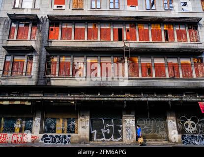 Eine Frau geht an einem vergangenen Gebäude in der Chinatown-Gegend von Bangkok, Thailand, vorbei Stockfoto