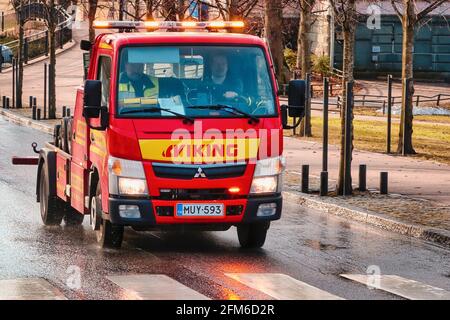 Rot Mitsubishi Radlift Abschleppwagen von Viking Assistance Oy fahren auf der Straße am Morgen, Lichter blinken. Helsinki, Finnland. 15. April 2021. Stockfoto