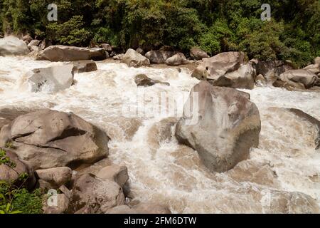 Das turbulente Wasser des Urubamba- oder Vilcanota-Flusses durchquert den Regenwald der Amazonas-Wolke, während er durch die Stadt Aguas Calientes in der Nähe von Machu Pi fließt Stockfoto