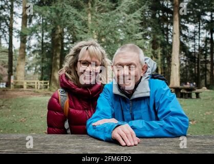 Vater und Tochter saßen draußen lächelnd auf einer Bank Wandern in Großbritannien Stockfoto