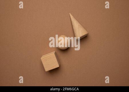 Holzspielzeug-Kindersorter mit kleinen Holzdetails in Form von geometrischen Formen Rechteck, Quadrat, Dreieck auf braunem Hintergrund, Figurenkonzept Stockfoto