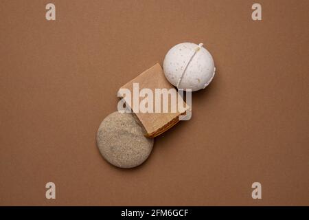 Verschiedene Spa- und Beauty-Produkte auf braunem Hintergrund, handgemachte Öko-Suppe und Vanilla Aroma-Badebombe in Trendfarbe Stockfoto