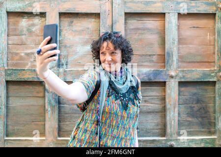 Eine moderne Frau mittleren Alters, die ein Foto von ihrem Smartphone gemacht hat Stockfoto