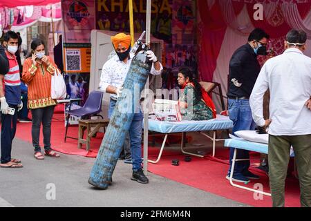 Ghaziabad, Indien. Mai 2021. Ein Sikh-Freiwilliger trägt eine Sauerstoffflasche in einer provisorischen Klinik außerhalb des Gurdwara Damdama Sahib. Indien steht vor einem Mangel an medizinischem Sauerstoff, und unter solchen Umständen hilft eine NGO namens „Khalsa Help International“ Covid-19-Patienten, indem sie ihnen freien Sauerstoff anbietet. Kredit: SOPA Images Limited/Alamy Live Nachrichten Stockfoto