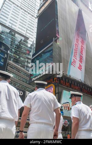 Drei Marinemänner laufen durch den Times Square in New York City, NY Stockfoto