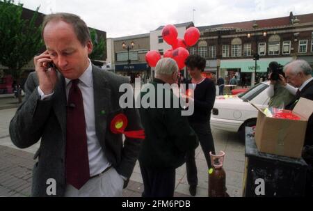 DIE PARLAMENTSWAHLEN AM 2001. JUNI SHAUN WOODWARD IM WAHLKAMPF AUSFLUG ZUM EINKAUFSZENTRUM IN ST. HELEN'S THE WOMAN IN SCHWARZ MIT DEN BALLONS IM HINTERGRUND IST SEINE FRAU CAMILLA Stockfoto