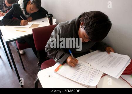 Ein Mädchen im Teenageralter von Xhosa nimmt während der Halbzeitsitzung der School of Hope eine Prüfung ab. Die School of Hope ist eine Basisschule in Athlone, Süd-A Stockfoto