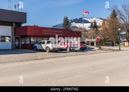 REVELSTOKE, KANADA - 16. MÄRZ 2021: Blick auf die Feuerwehrhalle der kleinen Stadt mit Autos und kanadischer Flagge. Stockfoto