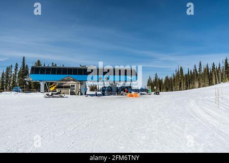 REVELSTOKE, KANADA - 16. MÄRZ 2021: Revelstoke Mountain Ski Resort Lift mit blauem Frühlingshimmel. Stockfoto