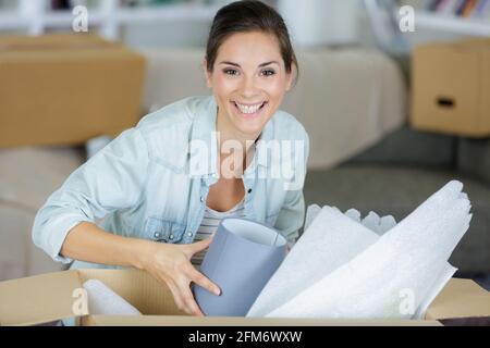 Frau zu Hause Auspacken Objekt aus Karton Stockfoto