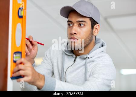 Handwerker mit einer Geisterebene an einer Wand Stockfoto