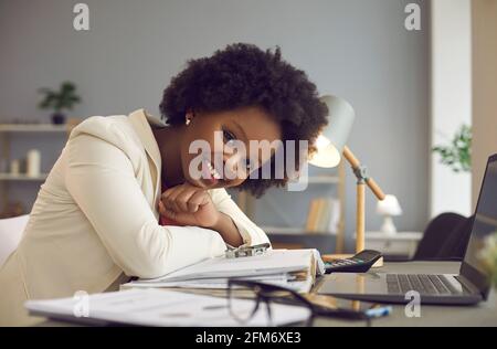 Glücklich lächelnd beiläufige schwarze Frau Büroangestellte nehmen Ruhe an Schreibtisch mit Laptop Stockfoto