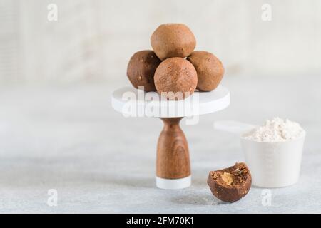 Gesunde Energie-Rohproteinbälle auf hellgrauem Tisch. Fitness Desserts, Snacks. Stockfoto