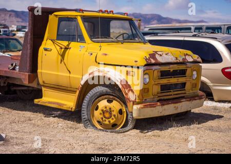 Rostiger gelber LKW mit einem Platten Reifen Stockfoto