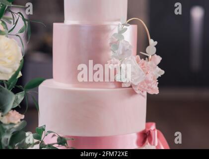 Nahaufnahme von rosa dreistufigen Hochzeitstorte mit Blumen Stockfoto