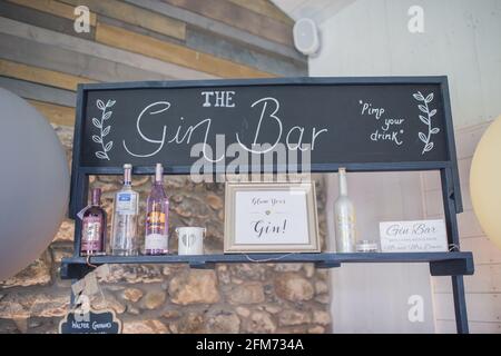 Eine Gin Bar mit vielen bunten Flaschen Gin vor einer Steinmauer bei einer Party, Veranstaltung oder Hochzeit Stockfoto