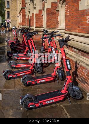 VOI Elektro-Scooter zu mieten auf einer Straße im historischen Zentrum von Cambridge. VOI Technology E-Scooter zum Mieten in einer Cambridge Straße. Stockfoto