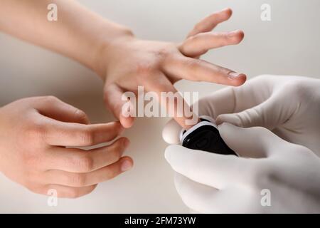 Der Arzt misst den Sauerstoff und die Herzfrequenz im Blut mit einem Pulsoximeter. Stockfoto