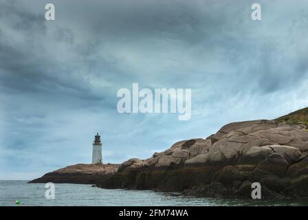 Die Sonne bricht durch wirbelnde Sturmwolken über dem Leuchtturm Moose Peak im Norden von Maine. Der alte rustikale Turm wird immer noch genutzt, um Seeleute davon abzulenken Stockfoto