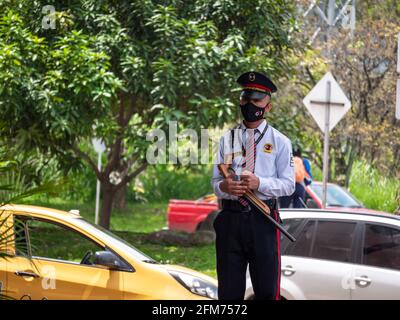 Itagui, Antioquia, Kolumbien - März 7 2021: Lateinischer Mann in Fußgängern die Sicherheitsuniform läuft herum und beobachtet die Menschen Stockfoto
