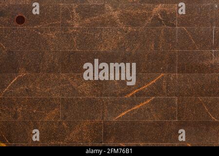 Flache Wand mit rechteckigen braunen Granitfliesen Auch bekannt als indischer brauner Granit Stockfoto