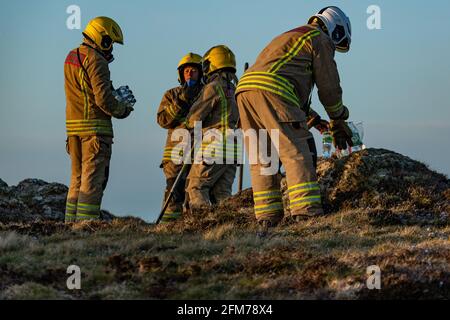 Feuerwehrmannschaften bekämpfen das Gorse-Feuer auf der Isle of Anglesey. Stockfoto